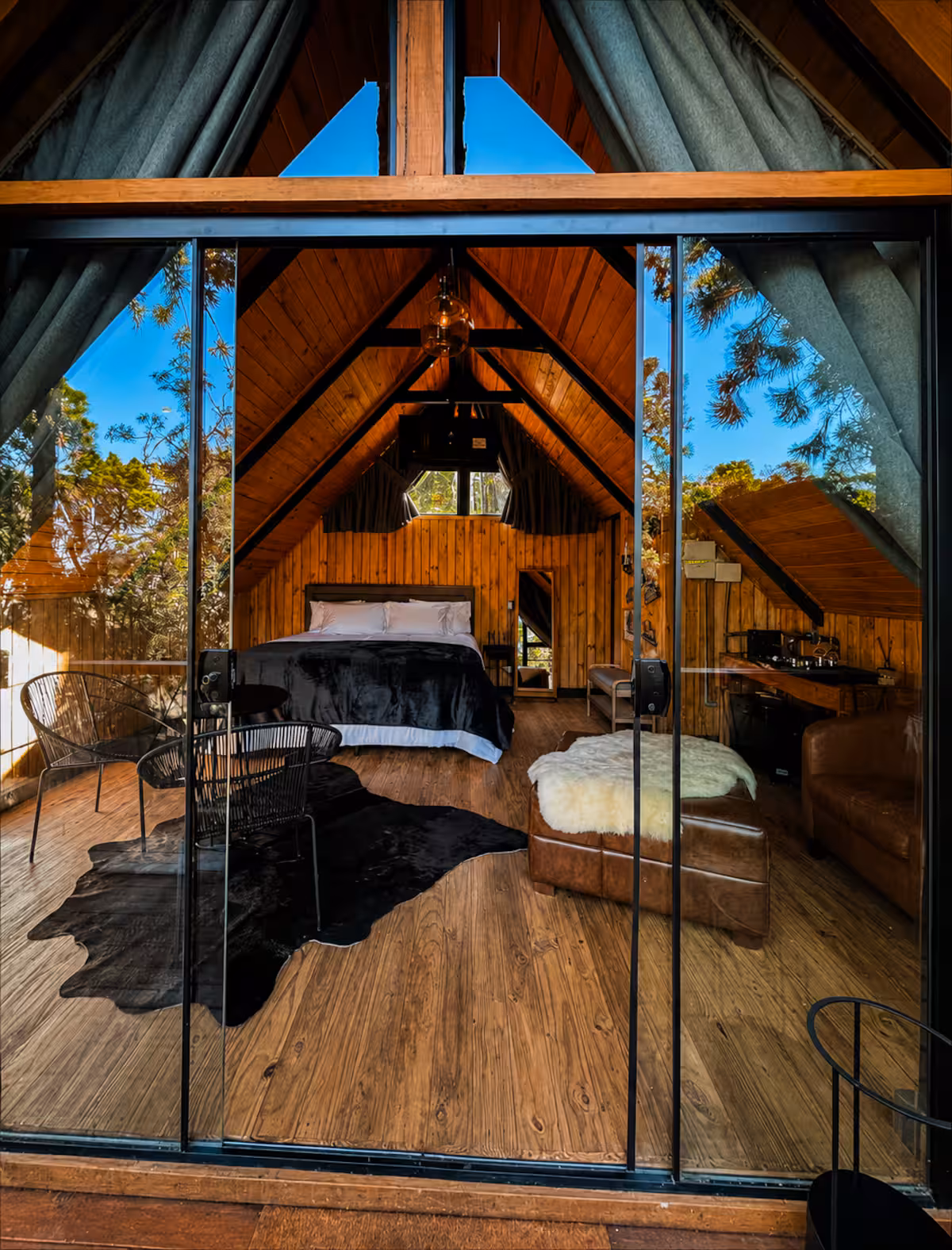 Cama Queen voltada para a janela com vista para a floresta